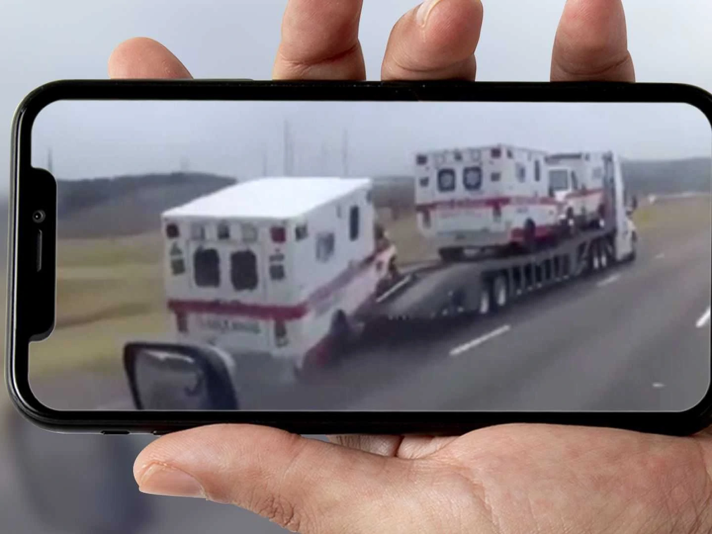 Watch an ambulance fall off a trailer and roll down the highway without a driver