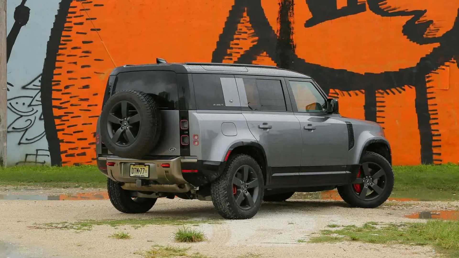 Car trailer with six Land Rovers pulled by a new Defender on Icy Road