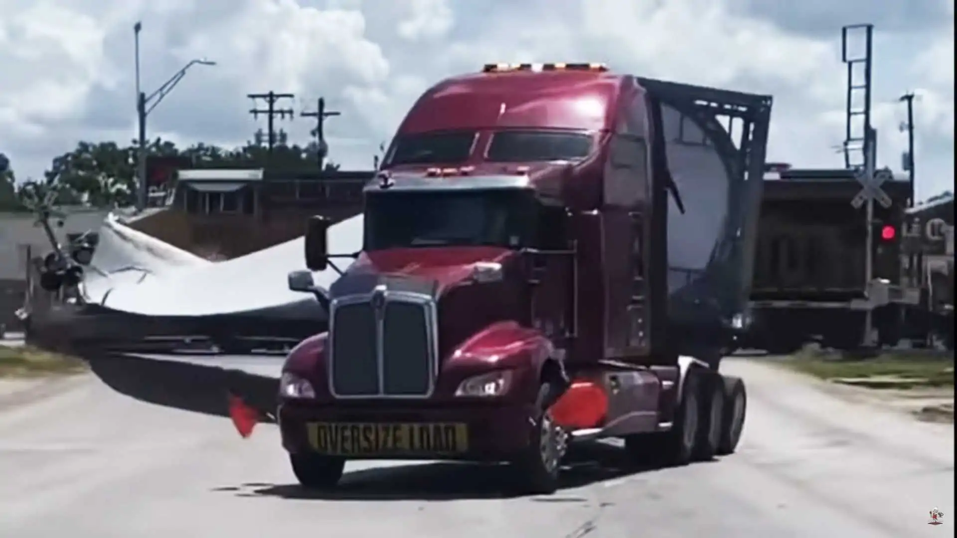 Watch Semi Trucks Hauling Large Turbine Blades Imposed by Freight Train